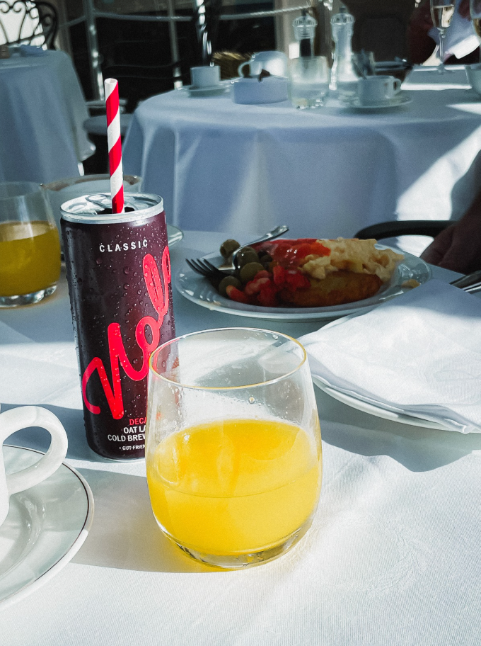 Photo of Nolo Classic on a hotel breakfast table with glass of orange juice
